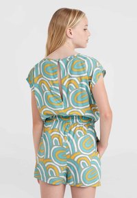 Kurzer Jumpsuit mit einem mehrfarbigen Muster in Türkis-, Gelb- und Weißtönen. Der Rücken hat einen Schlüsselaugen-Ausschnitt und einen elastischen Bund.