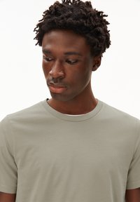 Light green crewneck t-shirt made from soft cotton fabric, featuring short sleeves and a smooth texture, without visible patterns or logos.