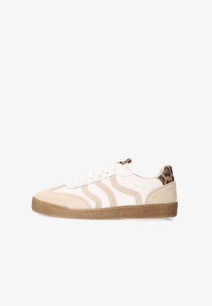 White and beige sneaker with wavy side stripes, brown rubber sole, white laces, and leopard print detail on the heel tab.