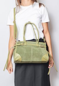 Borsa a tracolla verde in suede con dettagli in pelle liscia, due manici superiori, tracolla rimovibile e dettagli cuciti.