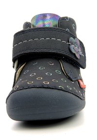 Navy blue shoe with velcro strap, featuring multicolored dot patterns and a flower accent. Rubber sole and soft textile upper.