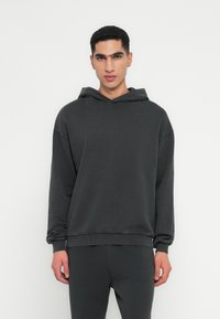 Anthrazitgrauer Hoodie aus weichem Stoff, mit lockerer Passform, langen Ärmeln und verstellbarem Kordelzug an der Kapuze.