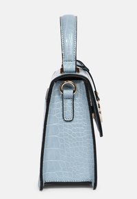 Lyseblå håndtaske med krokodilleskindsstruktur set fra siden, med top-håndtag og guldfarvet ringdetalje.