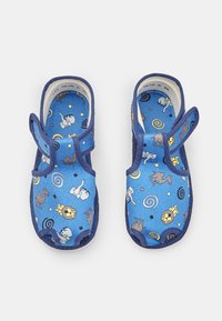 Sinised laste sandaalid, millel on takjakinnitused, ja millel on karikatuurid lõvidest, elevantidest, kaamelitest ja spiraalid valgel taustal.