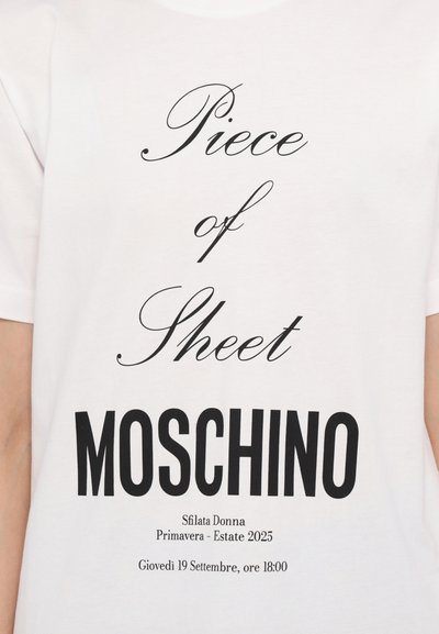 White cotton t-shirt featuring bold black text: "Piece of Sheet Moschino." Includes additional details about a fashion event and date.