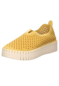 Scarpa gialla slip-on con upper perforato, motivo testurizzato e una spessa suola bianca con righe verticali.