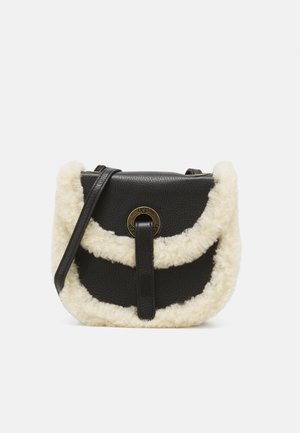Sac bandoulière en cuir noir avec garniture en shearling crème et fermoir rond doré sur le rabat avant.