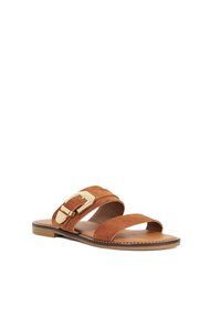 Bruine suède slippers met twee brede banden, een gouden gespaccent en een platte zool met een contrasterende gestikte rand.