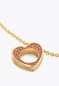 Pendentif en or en forme de cœur avec des pierres roses et iridescentes, comportant une ouverture circulaire au centre et une chaîne reliée.