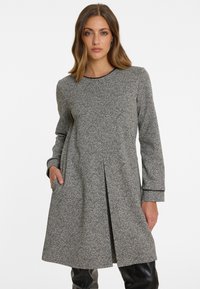 Graues, strukturiertes Kleid mit Rundhalsausschnitt, langen Ärmeln und Seitentaschen. Verfügt über einen gefalteten Rock und schwarze Paspeln entlang der Kanten.