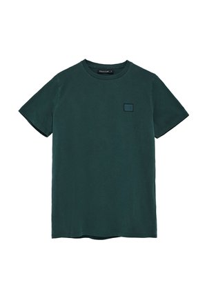 T-shirt en coton vert avec un col rond, des manches courtes et un petit logo carré noir sur la poitrine. Texture lisse et design décontracté.