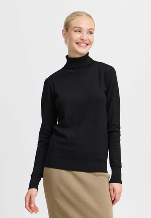 Pull à col roulé noir à manches longues en tissu lisse, avec un design ajusté et des poignets côtelés, associé à une jupe côtelée beige.