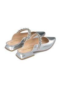 Scarpe slingback in satin argento con punta affusolata, fascia decorata con strass e tacco basso a blocco, caratterizzate da una texture liscia e una finitura lucida.