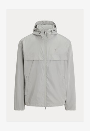Jasnoszara wodoodporna kurtka z kapturem, przednim zamkiem błyskawicznym, dwoma bocznymi kieszeniami oraz poziomym panelem na wysokości klatki piersiowej. Z delikatnym logo.
