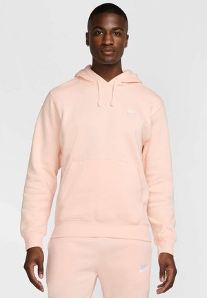 Roze Nike hoodie met een voorzak, capuchon met koord en wit logo op de borst. Zacht, gestructureerd materiaal en een relaxte pasvorm.