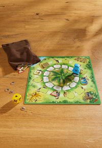 Board game with a colorful illustrated game board featuring a central green bush, game pieces, dice, and a brown fabric bag for tokens.