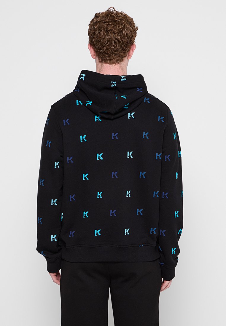 Hoodie noir arborant un motif répétitif de logos bleus et verts d'eau. Fabriqué dans un matériau doux, il possède une poche kangourou et une capuche réglable.