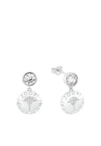 Smycken i silverfärg med en cirkulär design som har det ingraverade varumärket, en blommig emblem och en klar, rund cubic zirconia-sten högst upp.