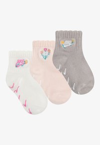 Drei Paare Ankle-Socken: weiß mit pinken Akzenten, pink mit floralem Stickdesign und grau mit gesticktem Nike-Logo und Blumen.