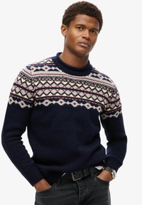 Navyblauwe gebreide trui met een Fair Isle-patroon in crème, rood en grijs op de schouderpartij. Ribgebreide manchetten en halslijn, casual pasvorm.