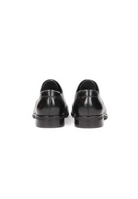 Zapatos de cuero negro con un acabado suave, punta redondeada, tacón bajo y costuras mínimas visibles en la parte trasera. Diseño sin cordones y fácil de poner.