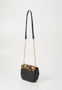 Black leather crossbody bag with a leopard print flap, featuring a gold chain and black strap. Compact design with a structured shape.