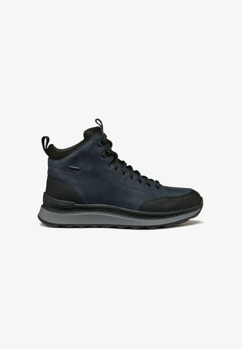 Botas de media caña hechas de cuero azul oscuro con acentos de goma negra, con cordones negros y una suela texturizada gris.