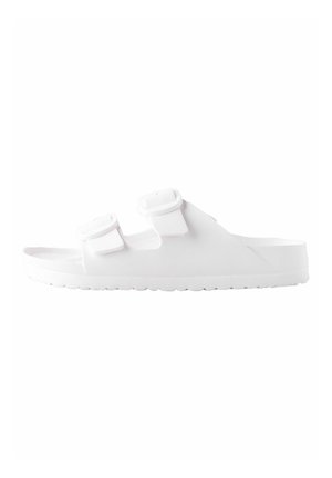 White slide sandal made of synthetic material featuring two adjustable straps, a textured footbed, and a rubber sole with a patterned tread.