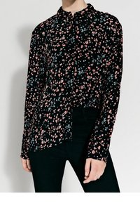 Svart långärmad skjorta med ett blommönster i rosa och blått. Har en knapp-down krage och rak skärning. Lättviktig tyg.