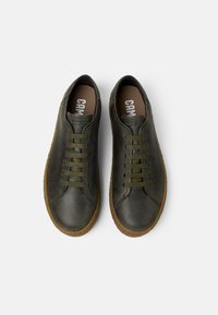 Tummanvihreät nahkakengät, joissa on pyöreä kärki, tasaiset nauhat ja kumipohja. Ominaisuuksia ovat kirjailut yksityiskohdat ja vaaleanruskea sisäpohja, jossa on brändäys.