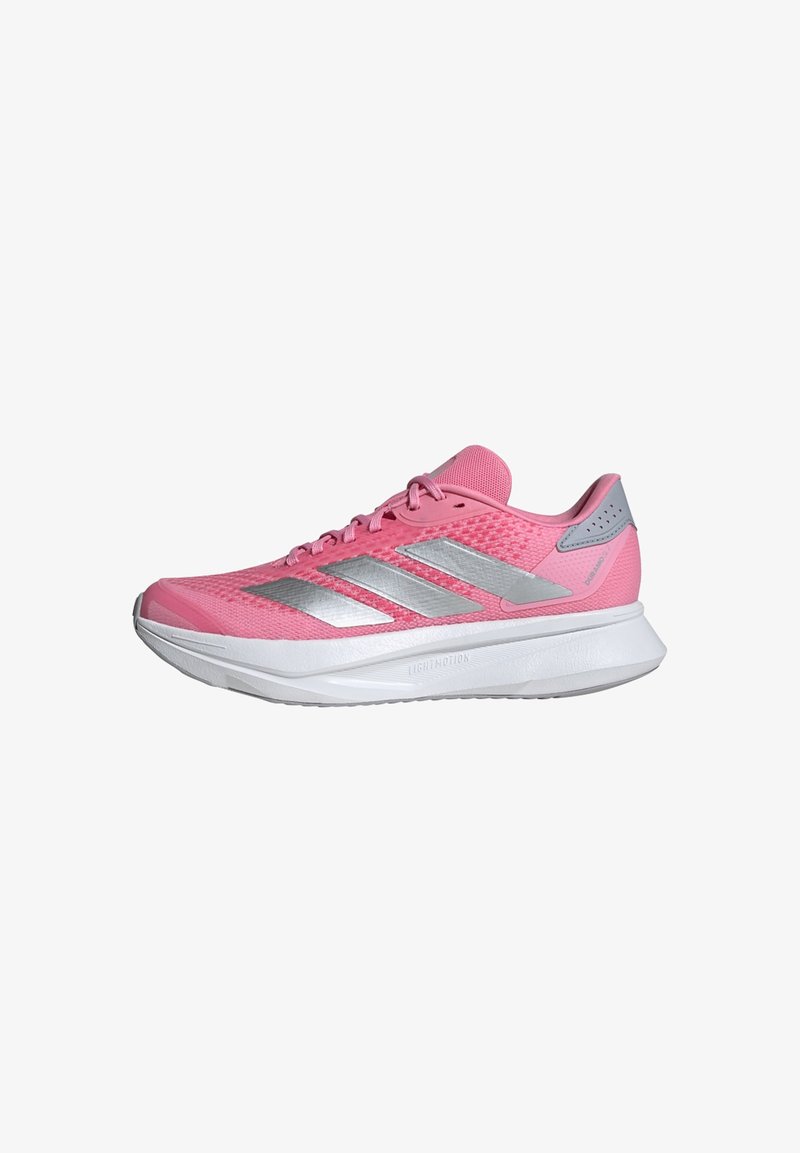 Zapatilla deportiva rosa con una parte superior de malla transpirable, tres rayas plateadas y una suela acolchada blanca. Presenta una puntera redondeada y un cuello acolchado.