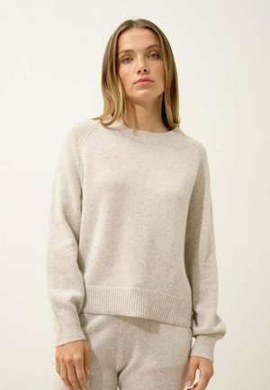Maglione in cashmere beige chiaro con scollo rotondo, polsini e orlo a coste, caratterizzato da una vestibilità comoda e una texture morbida.