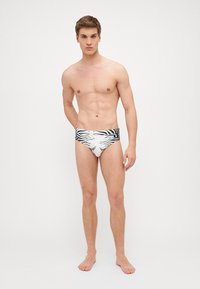 Slipuri de baie cu imprimeu zebra alb-negru și un brâu de o culoare solidă. Design elegant și ajustat, realizat dintr-un material neted.