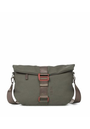 Sac bandoulière vert olive avec bandoulière réglable, fermeture par boucle centrale rouge atténué, et logo « KCB » embossé à l'avant.