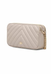 Kleciony beżowy skórzany portfel z złotym łańcuszkiem i zapięciem na zamek, z dyskretnym logo i wzorem w zygzak na powierzchni.