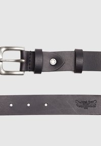 Ceinture en cuir noir avec une boucle métallique argentée, présentant une finition polie, cinq trous réglables et des détails embossés sur la sangle.