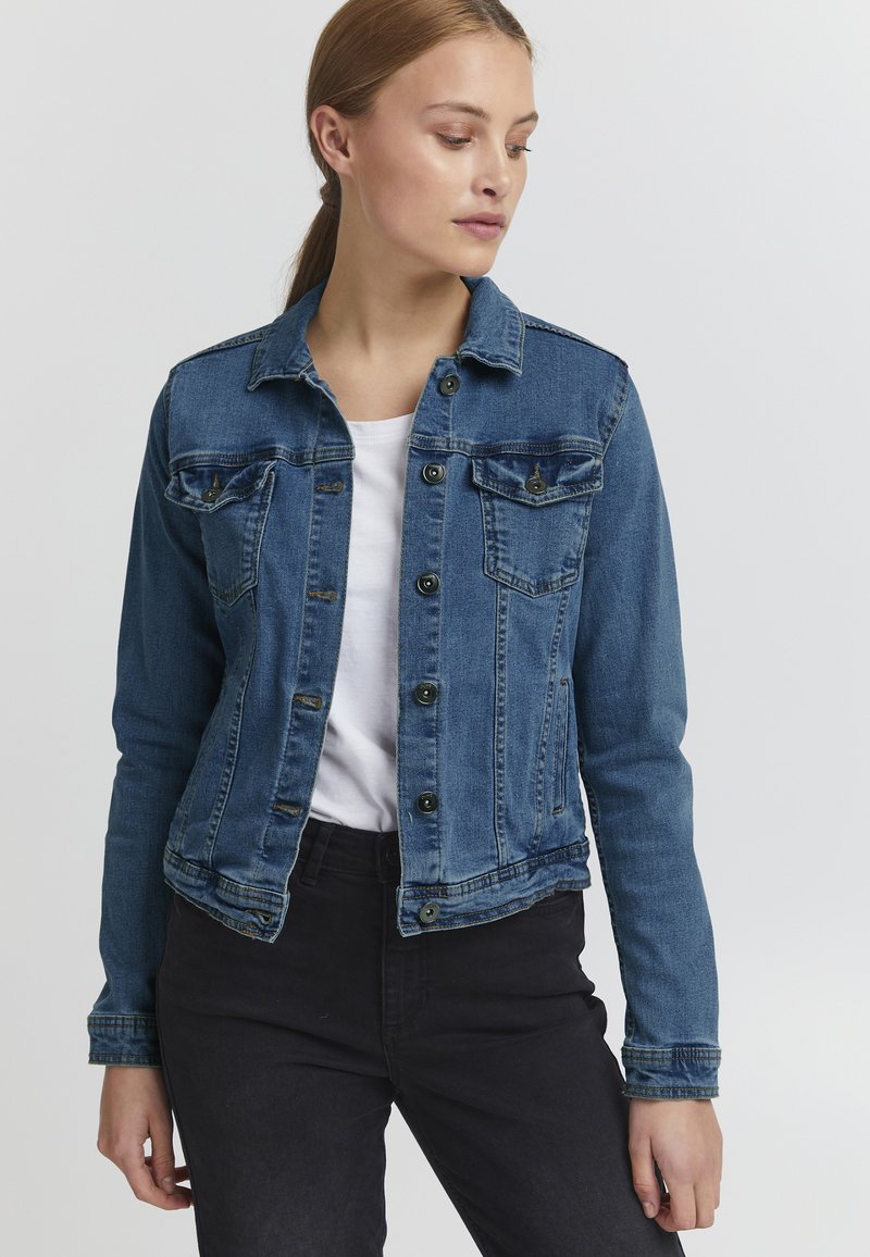 Denim jakna v srednje modri barvi, s sprednjim zapenjanjem na gumbe, dvema žepoma na prsih in krajšim krojem, klasičnim ovratnikom in dolgimi rokavi.