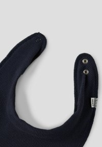 Granatowy, prążkowany śliniak o zaokrąglonym kształcie, z dwoma metalowymi napami i tkanym metkiem. Teksturowana tkanina z gładkimi krawędziami.