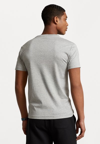 Tricou gri cu mânecă scurtă, fabricat din bumbac moale. Are un guler clasic și o textură netedă, fără modele sau accente vizibile.