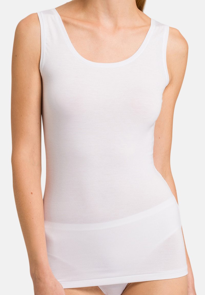 Hvid tanktop lavet af blødt, strækbart materiale, med en rund halsudskæring og brede stropper, har en tætsiddende pasform og sømløst design.