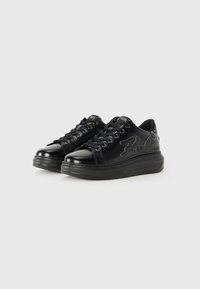 Black leather sneakers with thick soles, lace-up design, and stitched "Karl" logo on sides against plain white background.