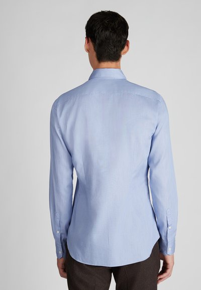 Hellblaues Langarmhemd mit Button-Down-Kragen, das eine glatte Textur und einen abgerundeten Saum aufweist. Inklusive Knopfmanschetten.