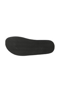 Suola di scarpa in gomma con un motivo testurizzato e ondulato. Il colore è nero puro, con punta arrotondata e design flat.