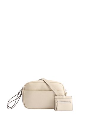 Kremowa skórzana torebka crossbody z odczepianym etui na karty, kieszenią zapinaną na zamek oraz gładką teksturą. Posiada długi regulowany pasek.