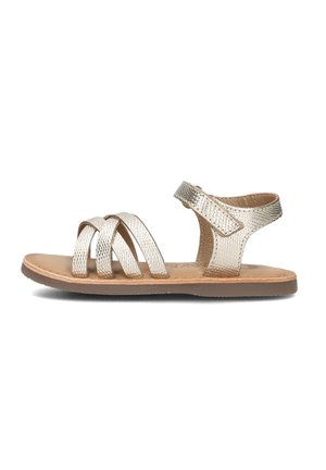 Metallische goldene Sandalen mit mehreren geflochtenen Riemen, einem geschlossenen Rücken und einem Klettverschluss am Knöchel. Glatte Textur und flache Gummisohle.