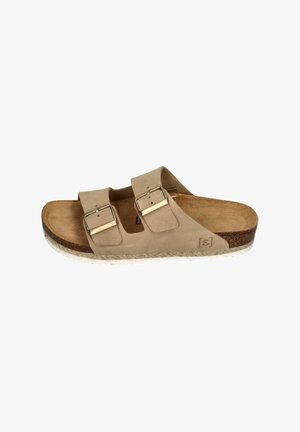 Beige suede slide sandal with two adjustable straps, metal buckles, and a cushioned footbed, featuring a textured cork midsole and rubber outsole.