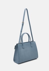 Rakennettu sininen käsilaukku, joka on valmistettu sileästä materiaalista. Siinä on kaksi lyhyttäkantokahvaa ja pitkä säädettävä olkahihna. Koristeina ovat suorakulmainen muoto ja minimalistinen muotoilu.