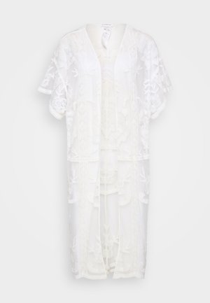 White lace kimono with short sleeves, featuring floral embroidery and open front design. Lightweight, sheer texture with a relaxed fit.