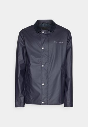 Veste imperméable navy avec fermetures à pression, col noir doux, logo Lyle & Scott et poches latérales. Texture lisse, design décontracté.