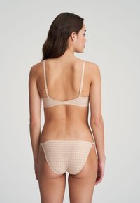 Nude-bralette ja vastaava bikinit-setti, valmistettu pehmeästä puuvillasta, jossa on ruutukuosi. Setissä on säädettävät hihnat ja pitsireunat.